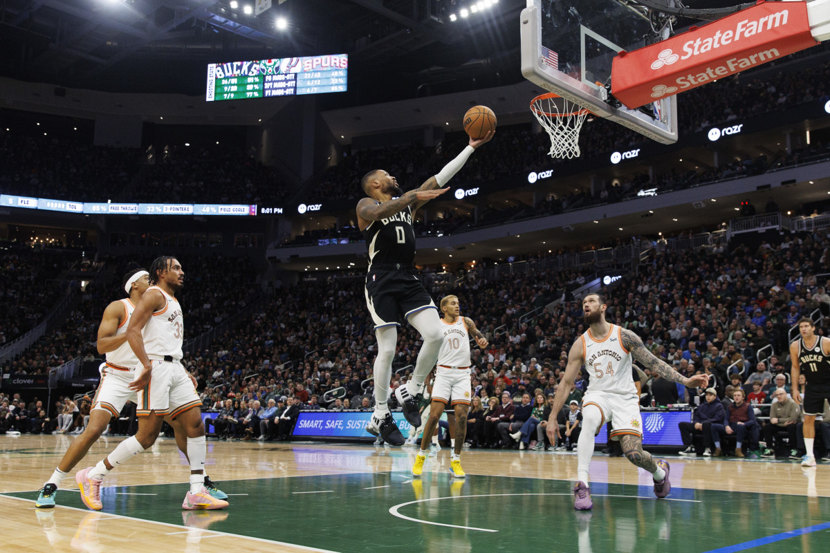 Dec 19, 2023; Milwaukee, Wisconsin, USA; Milwaukee Bucks guard Damian Lillard (0) drives for a layup  against the San Antonio Spurs at Fiserv Forum.